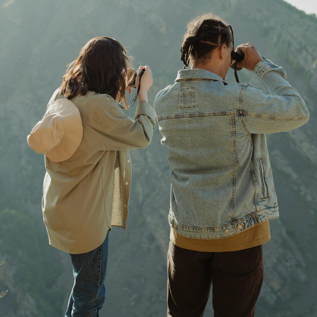 A couple bird bird-watching atop a mountain