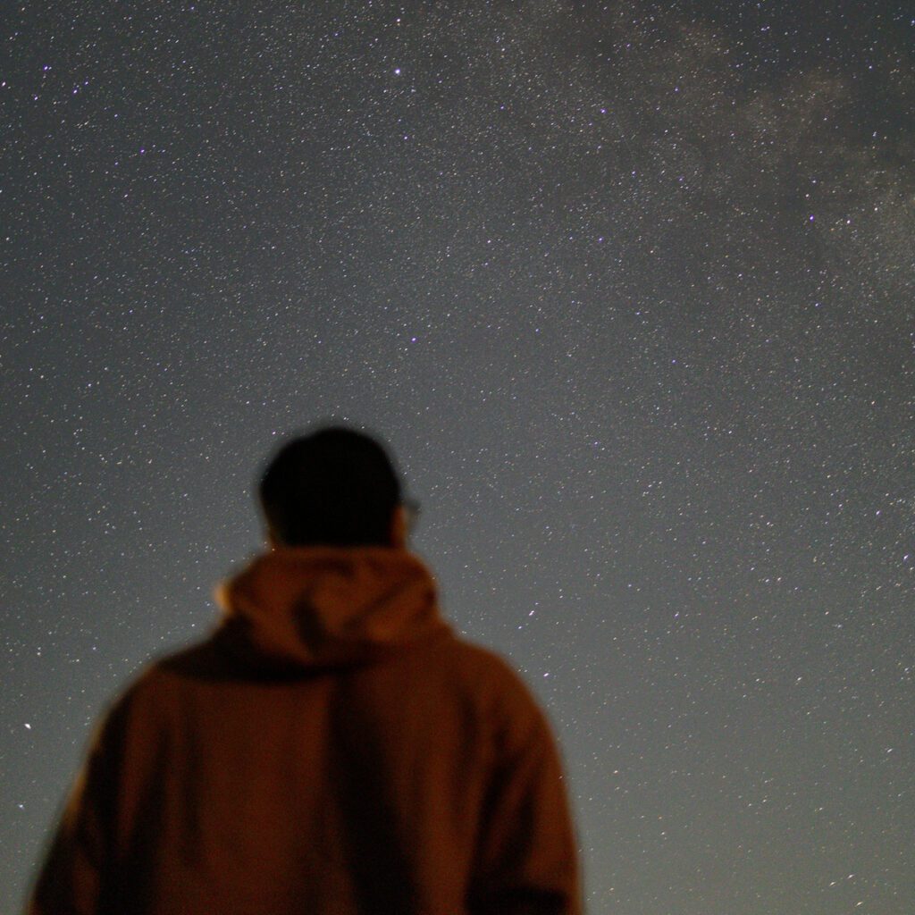 A man looking at the stars above him