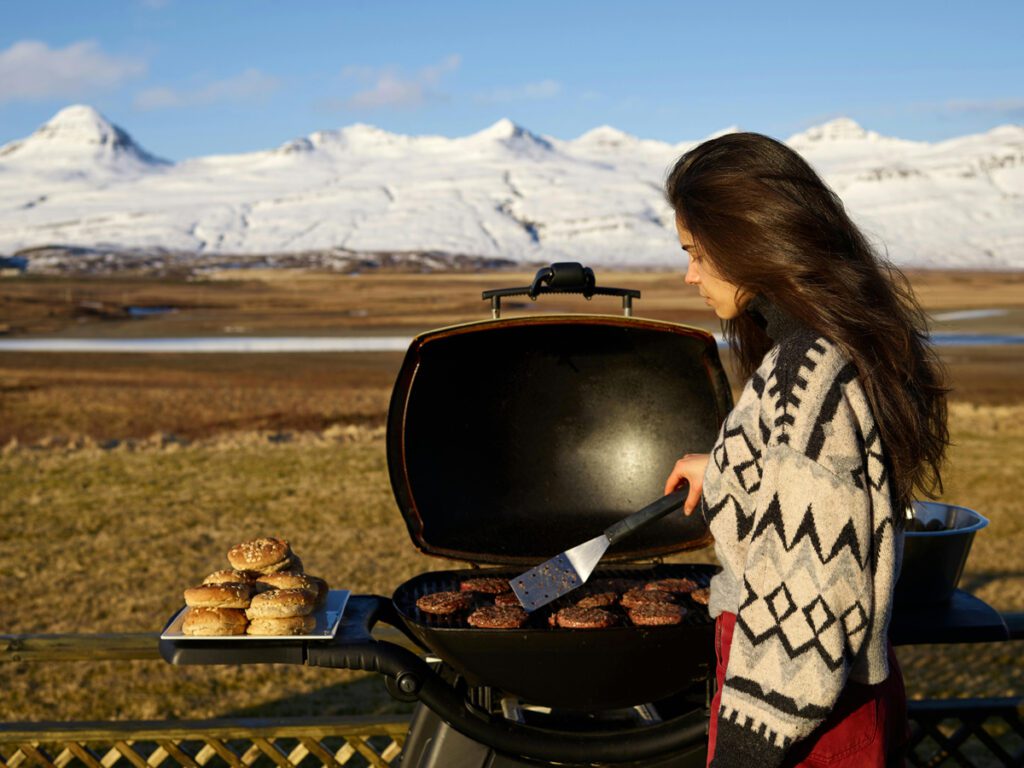 a lady grilling burgers outdoor