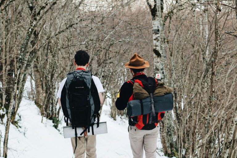 two men walking outdoors in snow - camping clothes ideas