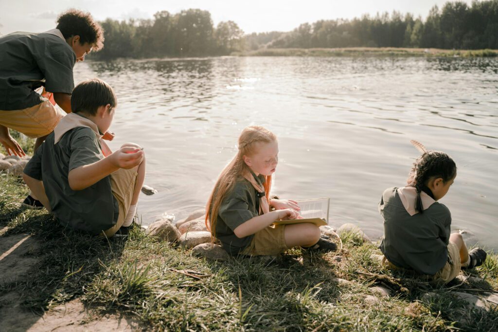 four kids enjoying their time beside a lake