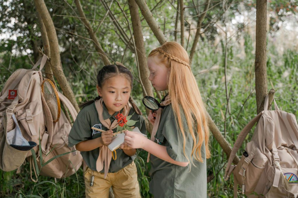 two girls studying the plants while outdoors