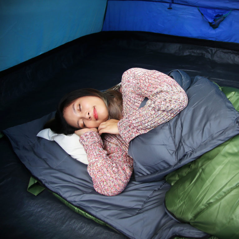 Girl sleeping inside a sleeping bag.