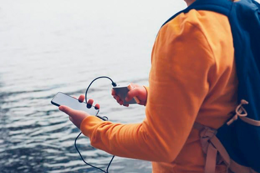 A Person Charging Phone while Hiking