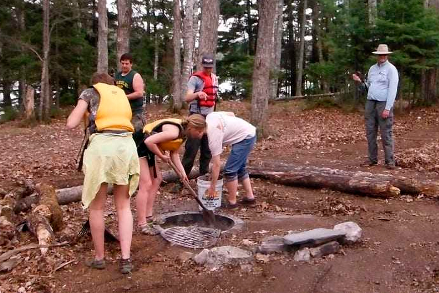 Group Of People Cleaning Campsite