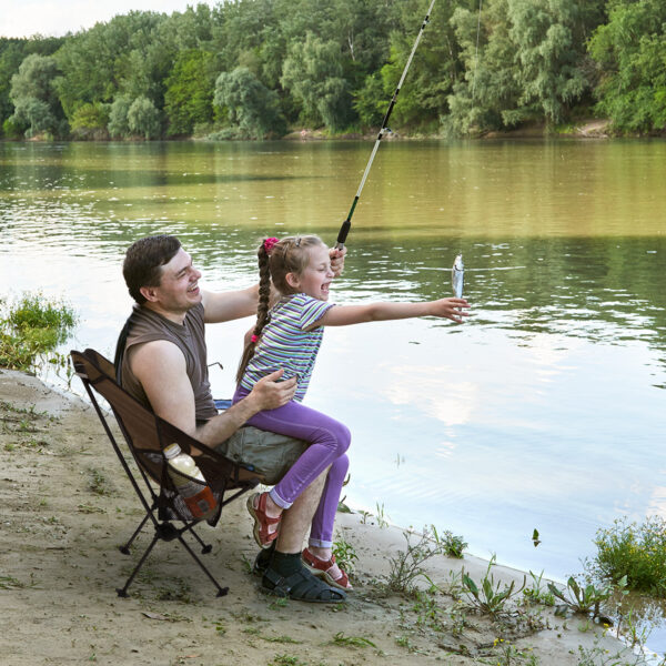 Father and daughter sitting in a fishing chair