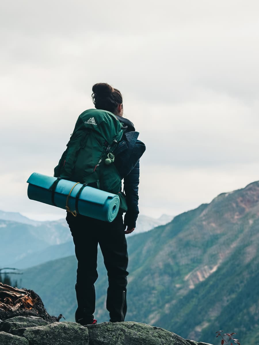 Woman climbing with his camping equipment