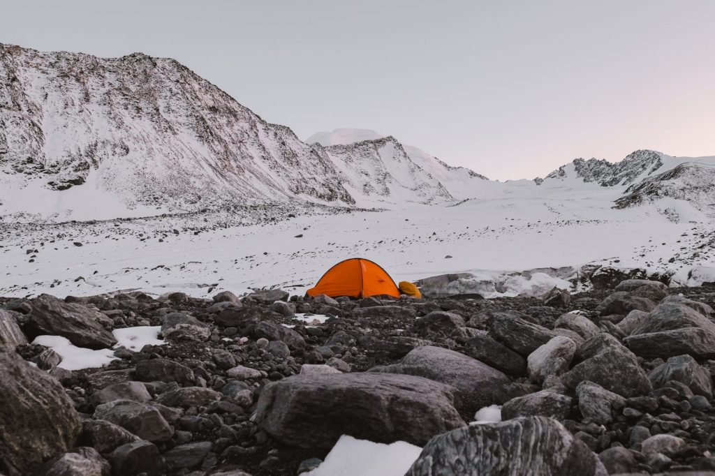 Orange tent in snowy mountains