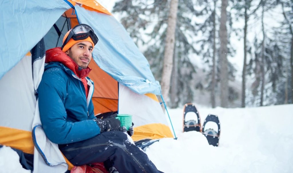 A man with multiple layers of clothing for winter camping