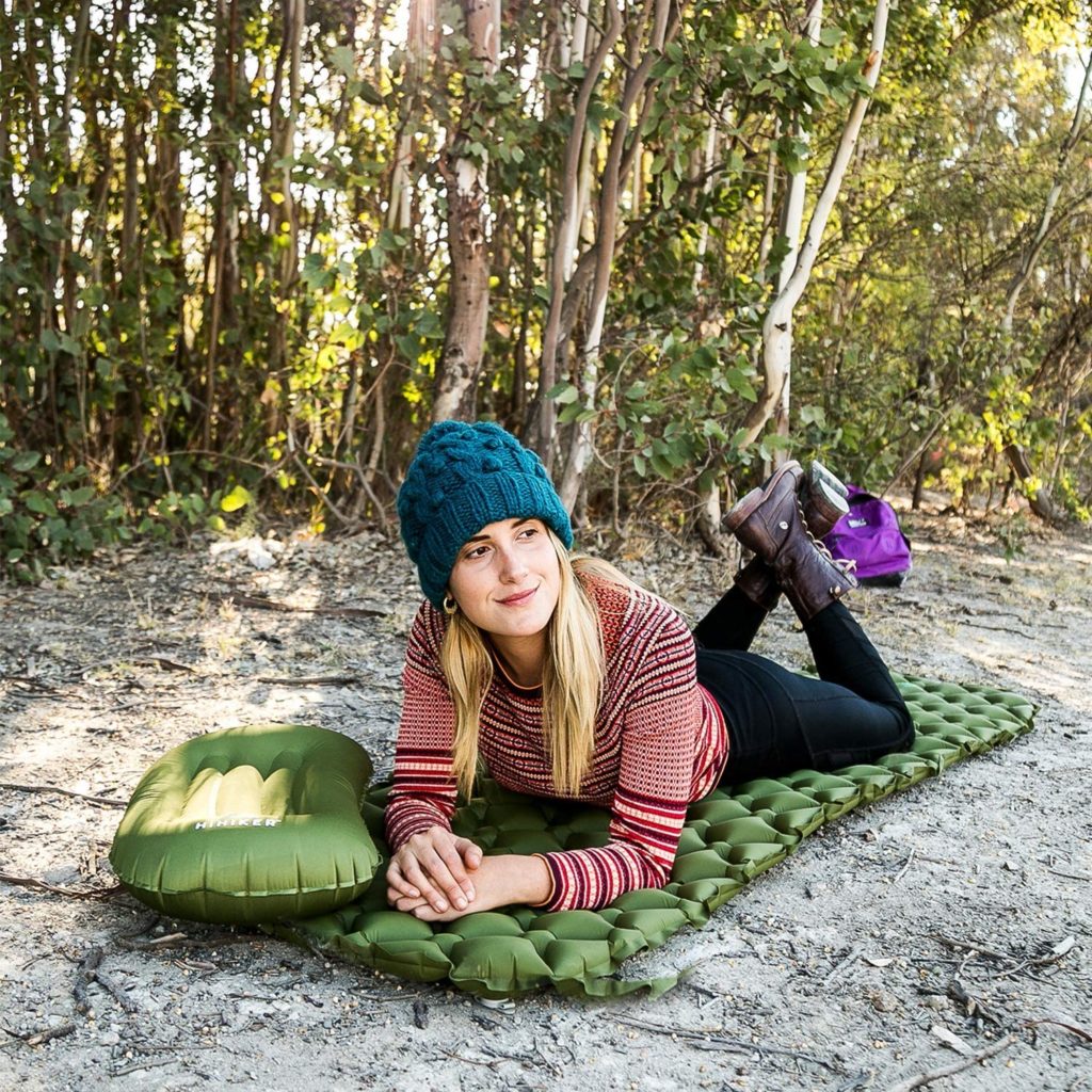 Woman laying down on green sleeping bag