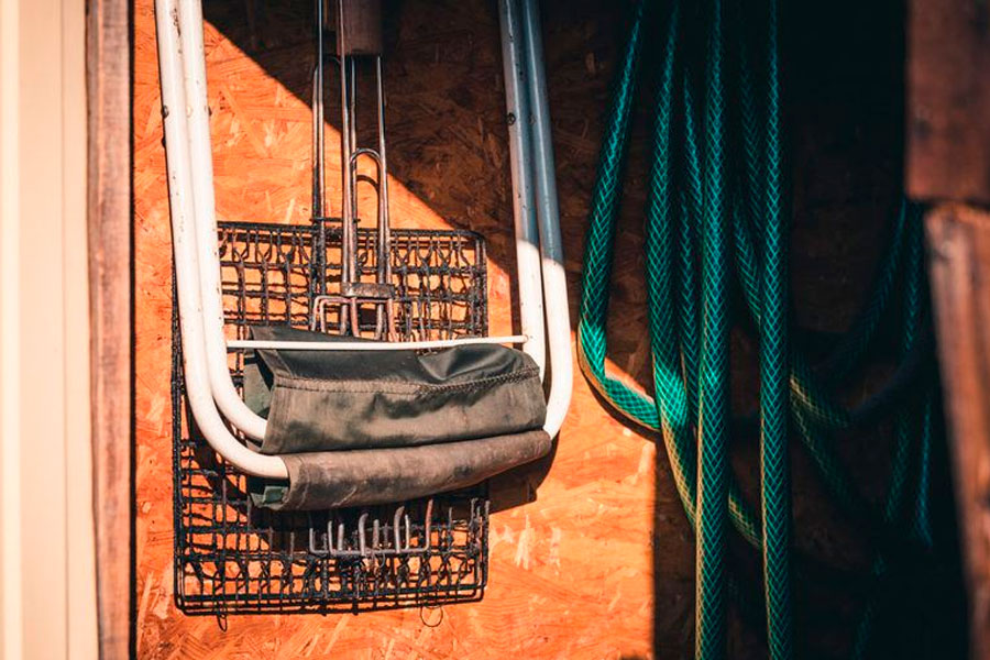 Folded fishing chair for fisherman hangs on clove together in a barbecue grill.