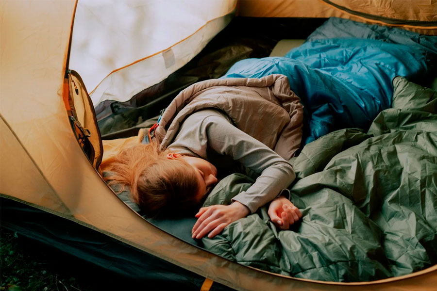 woman sleeping in tent on sleeping pad