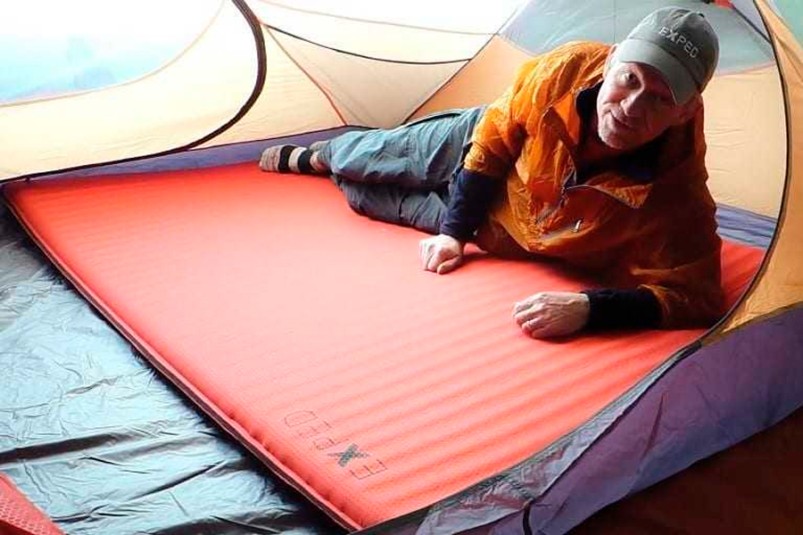 Backpacking sleeping pad side outlet sleeper