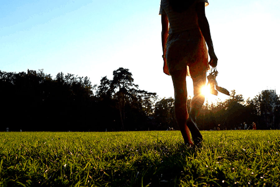 Girl Walking Barefoot In The Grass
