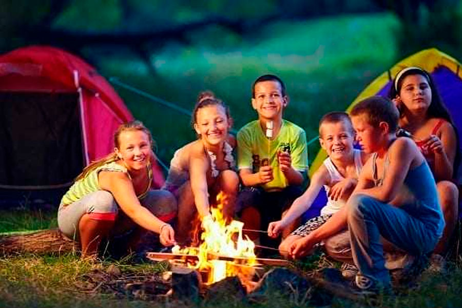 Chindren gathered around a camping fire