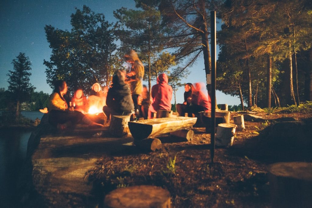 family camping vacation in front of campfire