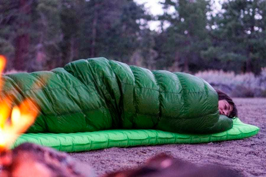 Backpacking sleeping pad side outlet sleeper