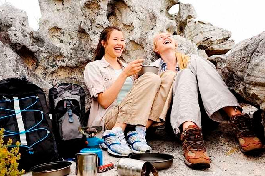Two women laughing while camping