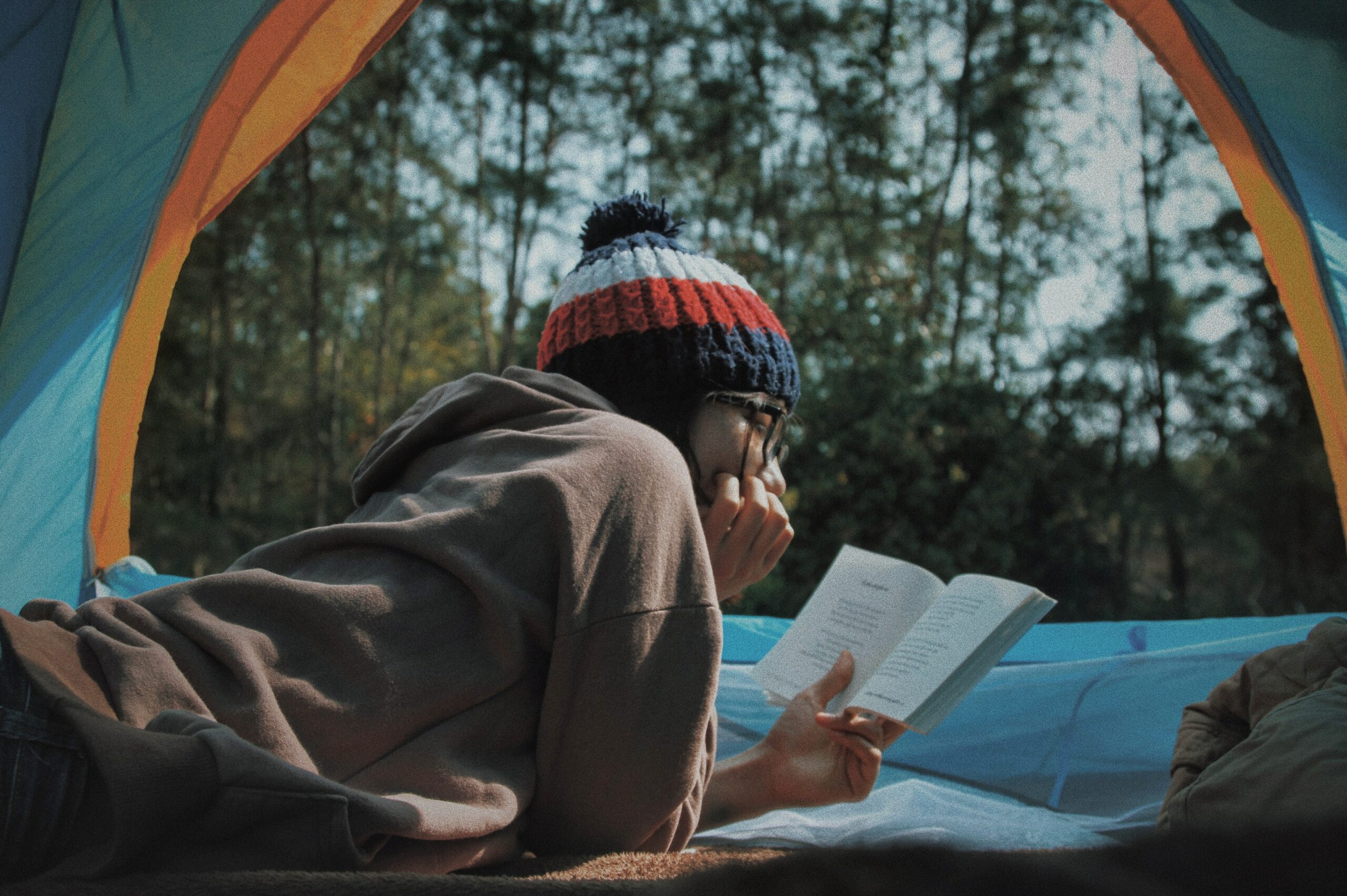 A lady reading inside a tent