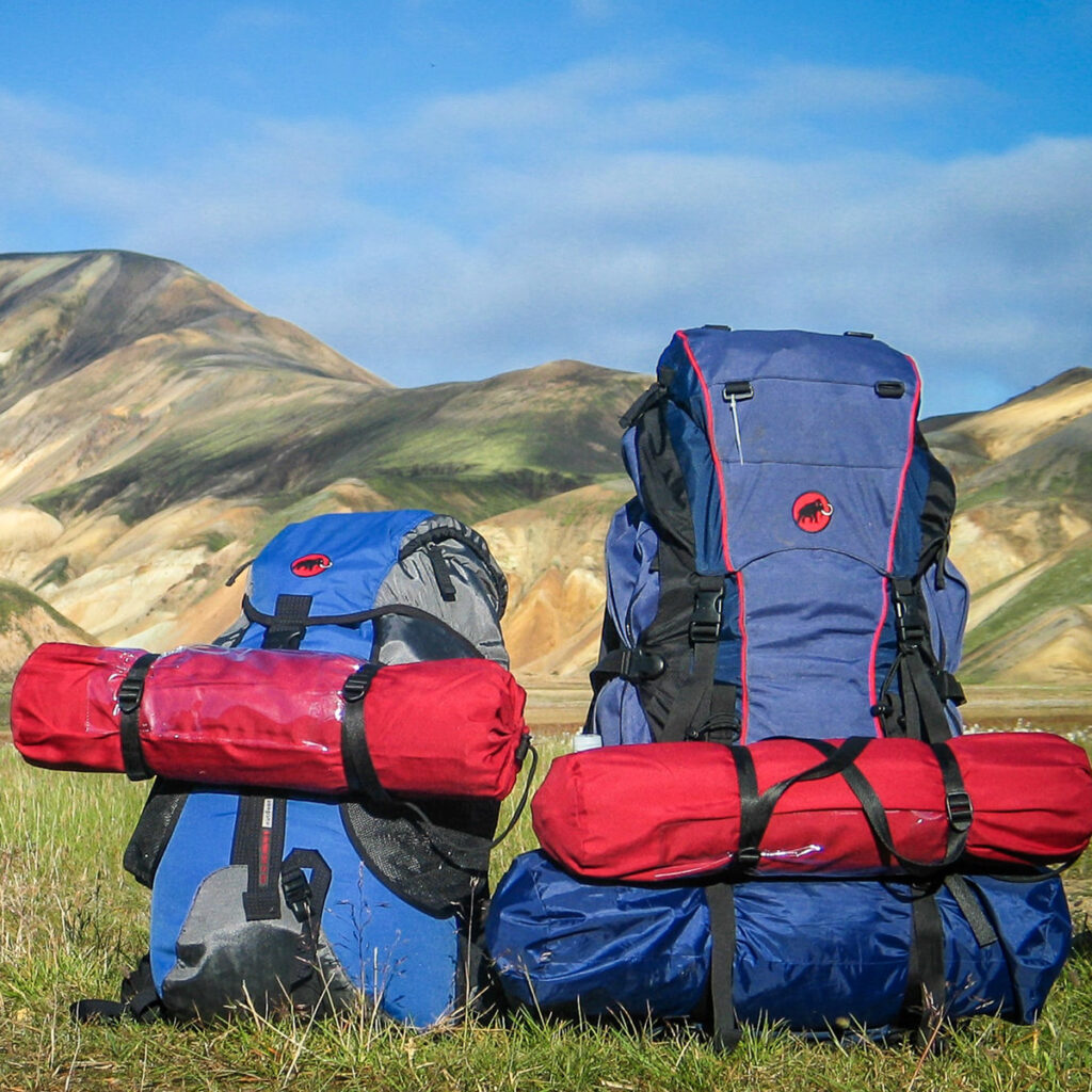 Two backpacks with attached sleeping pads