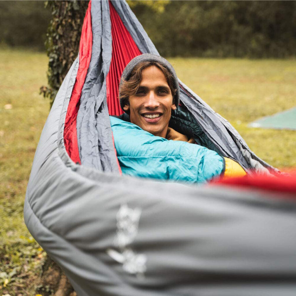 A man lying on a hammock with an  underquilt