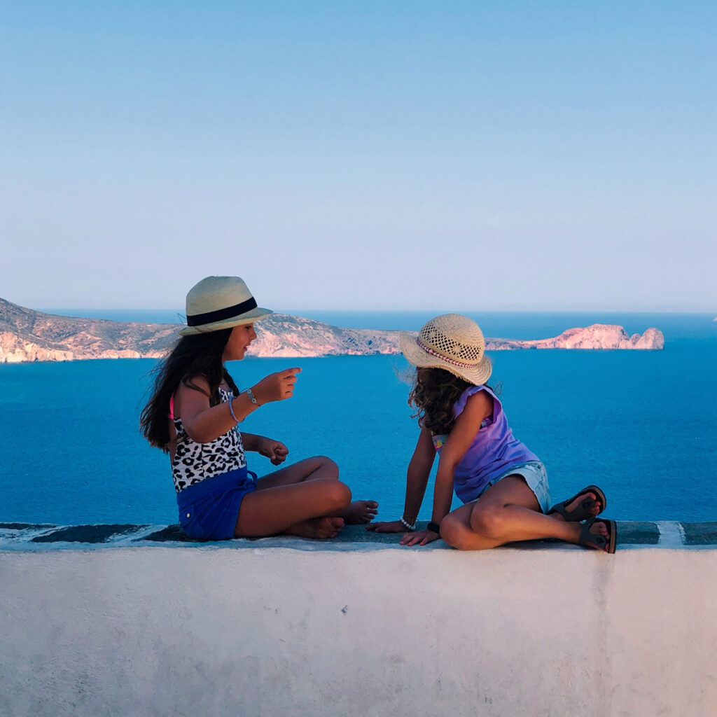 Two kids wearing hats on the beach