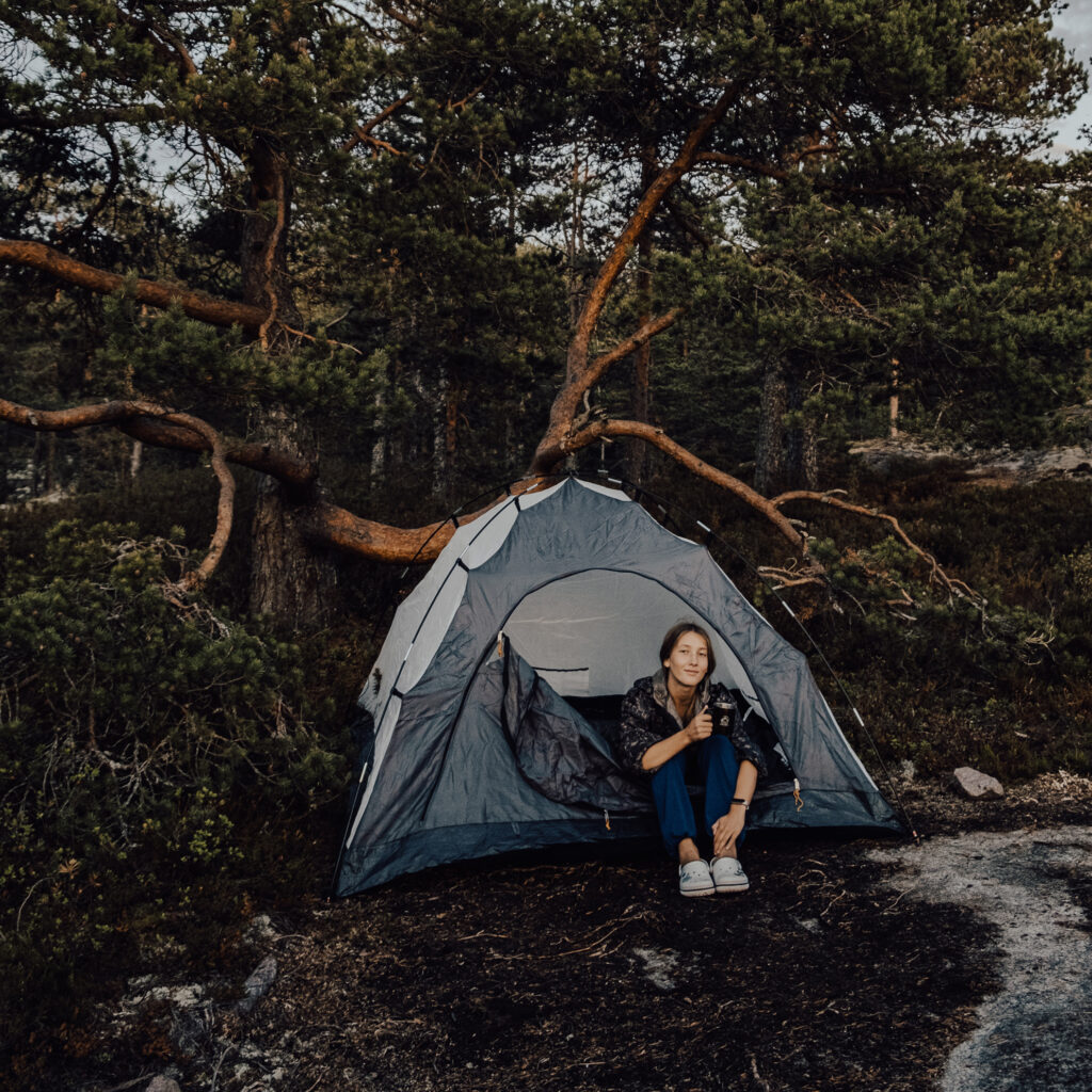 A lady sitting beside a tent