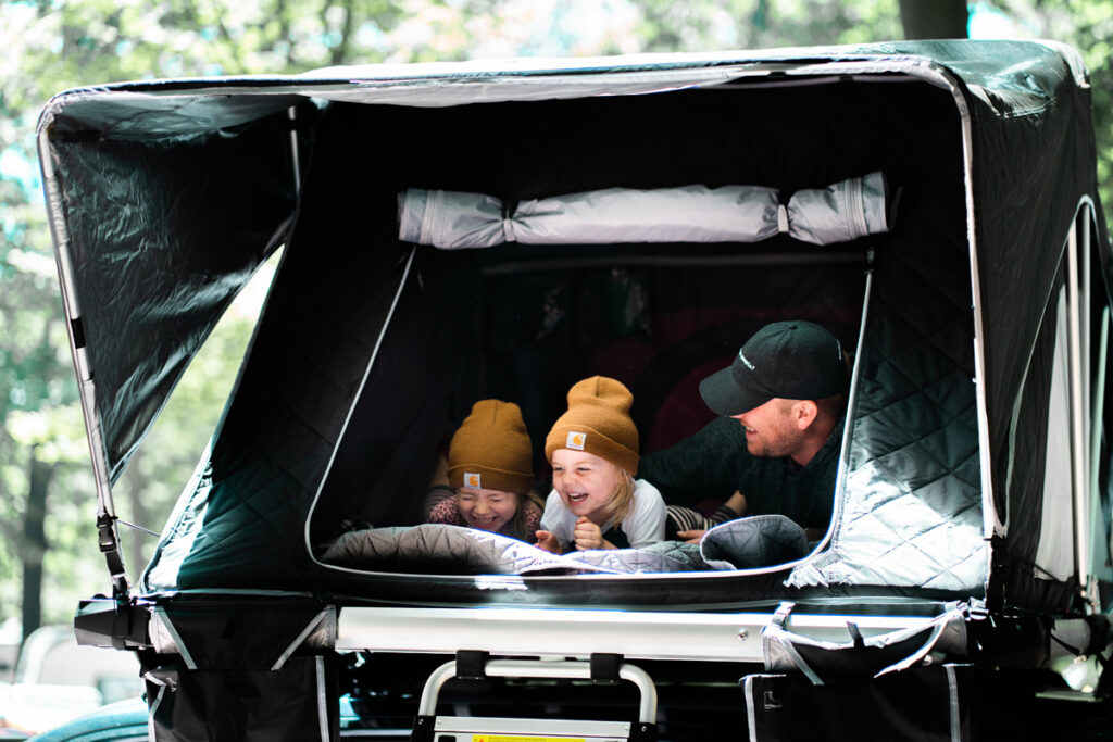 A father and his kids having fun in their car bed setup
