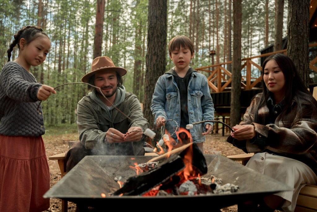 A family grilling marshmallows on a campfire