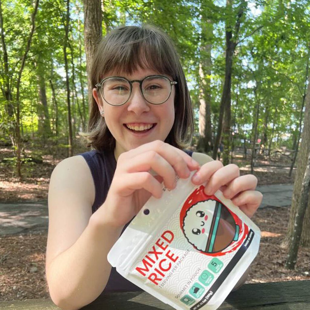 A woman holding a pouch of the KAMUI Mixed Rice