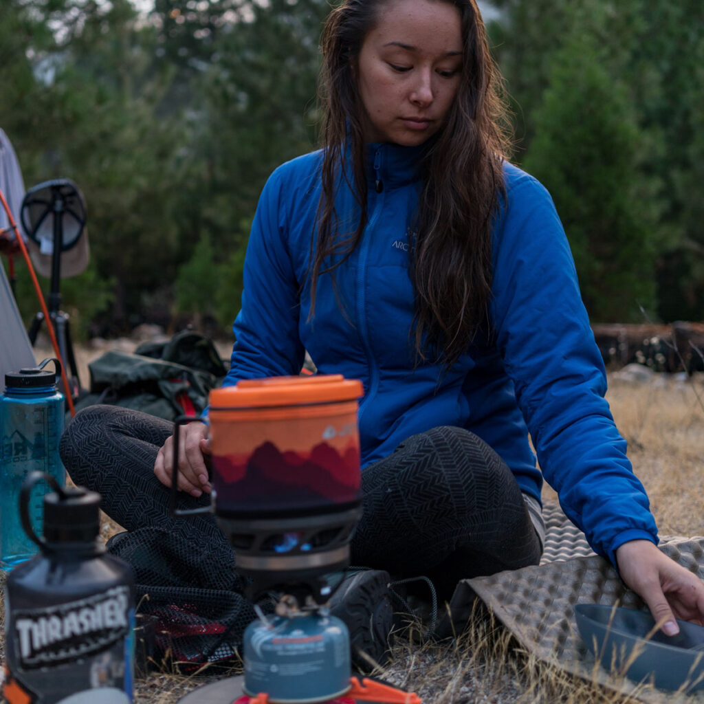 A backpacker cooking her food