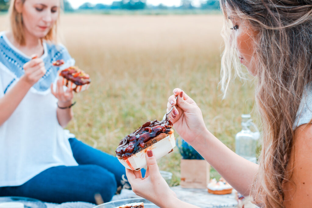 Two women eating bread outdoors