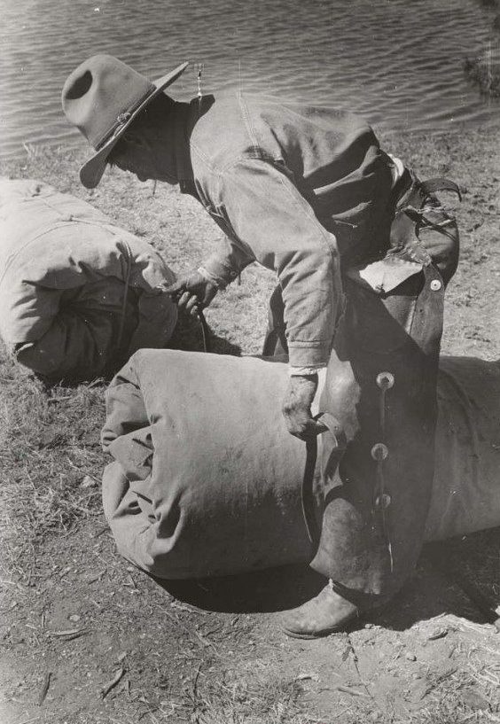 A cowboy fastening his bedroll
