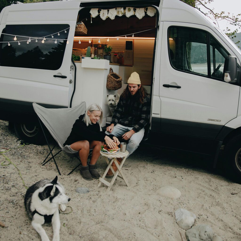 A dog and his fur parents outside a campervan