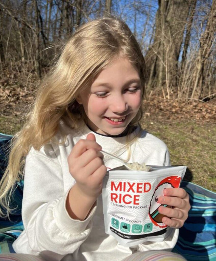 A young girl trying the kamui freeze dried food