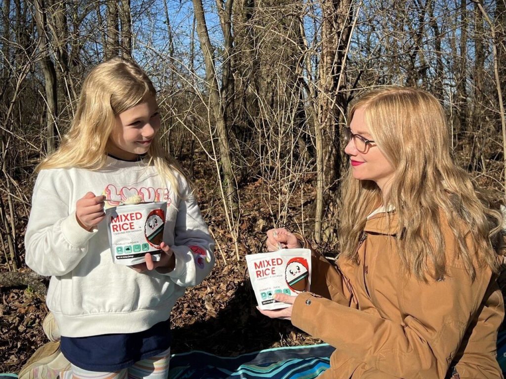 two girls enjoying kamui mixed rice on the trail