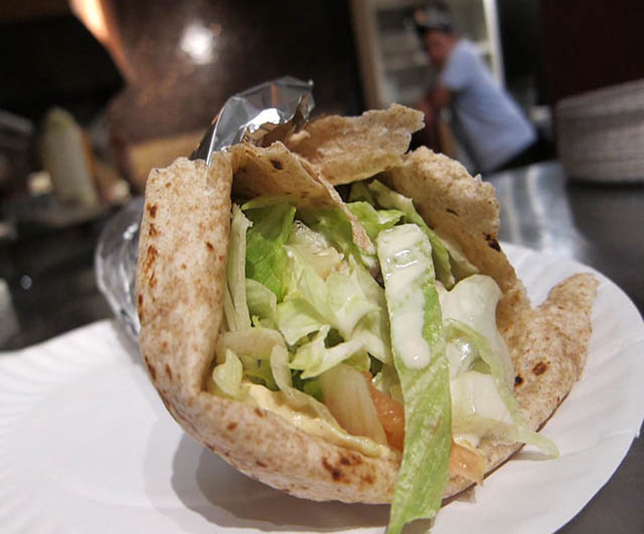 hummus wrap with salad and protein in tin foil